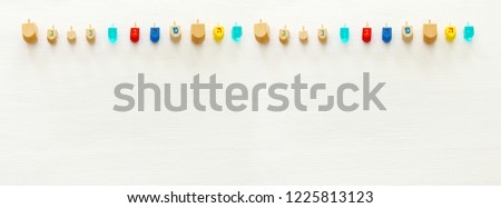 Image of jewish holiday Hanukkah with wooden dreidels colection (spinning top) over white background