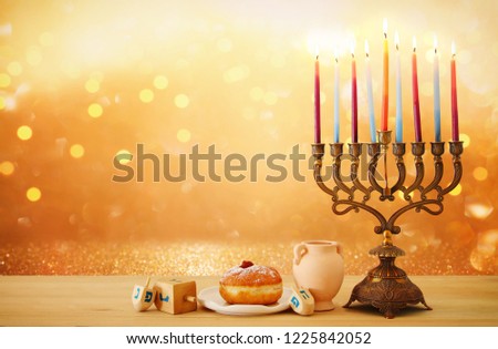 image of jewish holiday Hanukkah background with menorah (traditional candelabra) and candles over glitter shiny background