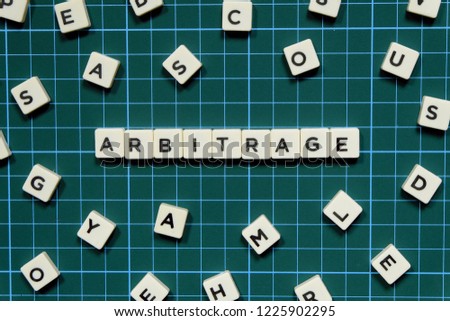 Arbitrage word made of square letter block on green square mat background. Royalty-Free Stock Photo #1225902295