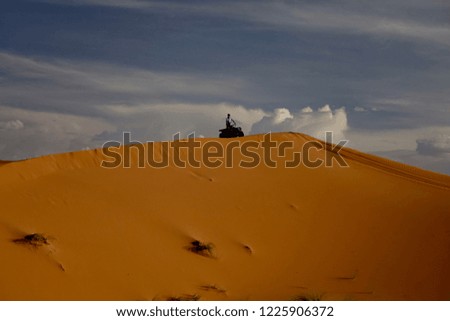           The big sand dune and small 4x4 on the top of it in the beautiful sunset light                      