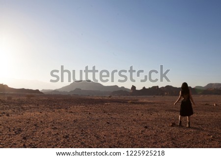 Beautiful young woman in Timna, desert in Israel. Rocks in sunset time. Mystic concept