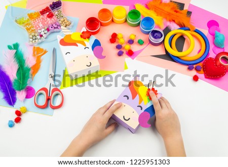 Child sticks hand craftwork unicorn. Unusual gift from paper box. Master class handmade. Favorite hobby. Kindergarten and school. Royalty-Free Stock Photo #1225951303