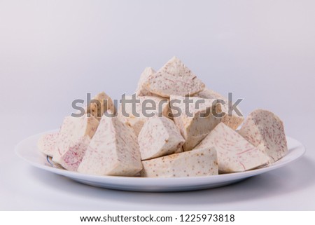 taro root in plate on white background