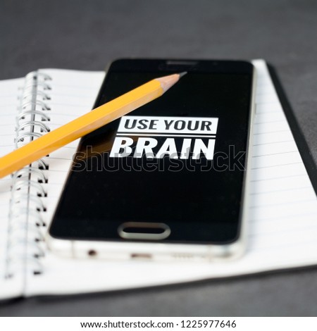 Use your brain concept with mobile phone and diary square format.
