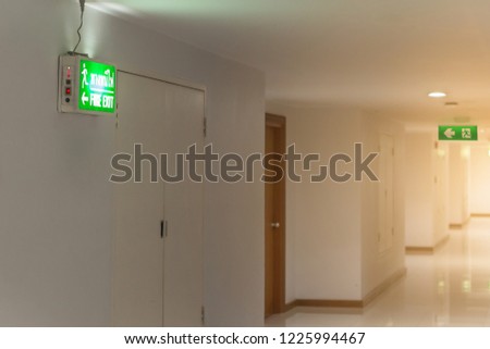 green emergency exit sign in hotel showing the way to escape
