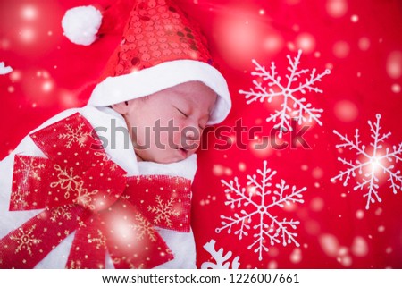 Newborn baby sleeping on santa het and red background, christmas or happy new year concept