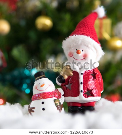 Smiling Santa Clause and snowman  standing on snow with Christmas tree background