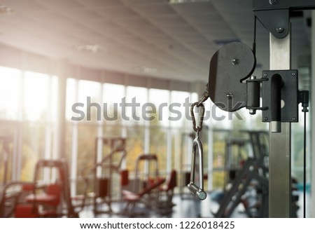 Blurred empty gym. Vertical weight lifting element, vertical traction. Panoramic picture - Modern gym interior with equipment.