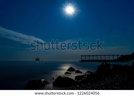 Moon over sea and stone coast at night