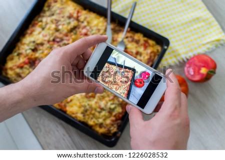 Man taking picture for his pizza before digging in