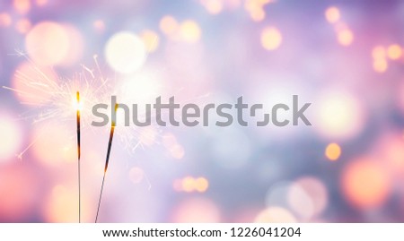 two sparklers on abstract pastel background Royalty-Free Stock Photo #1226041204