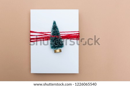 Miniature Christmas tree gift box on a light brown paper background