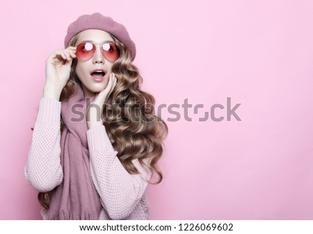 beautiful young female model with long wavy hair wearing pink beret , scarf and eyeglasses, close up