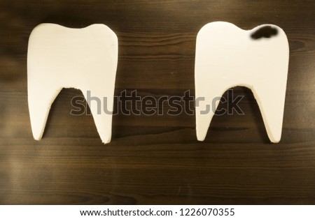 two teeth on a dark background with caries