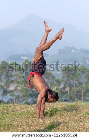 Healthy life exercise concept - Indian yogi doing handstand outdoors in Kerala, South India