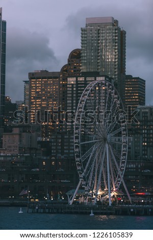 The ferris wheel on the Seattle Washington waterfront at dusk with the skyline in the background