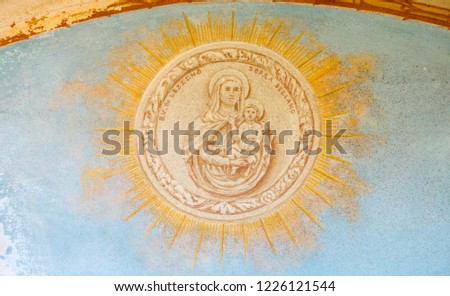 Holy Mary with her son Jesus in the arm. Fresco painting with circle in ray of sun.