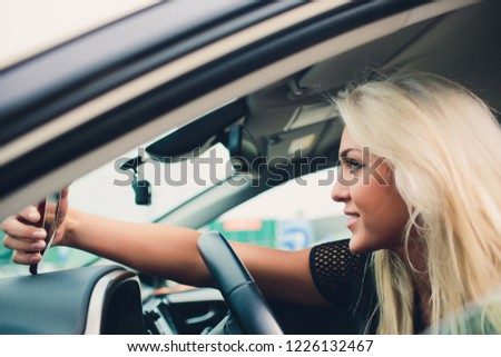 Holidays and tourism concept - smiling teenage girl taking selfie picture with smartphone camera outdoors in car.
