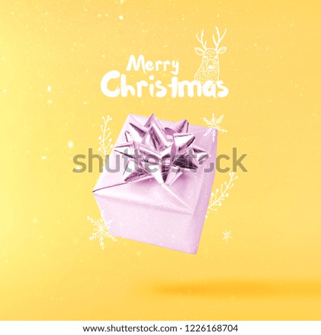 Christmas concept.  Creative Christmas conception made by falling in air silver gift box over yellow background. Minimal concept