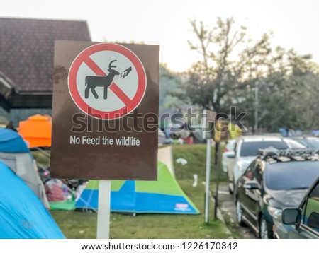 Do not feeding sign with camping and car park background
