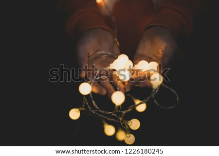 Christmas garland in the hands of a child. Decoration background Royalty-Free Stock Photo #1226180245