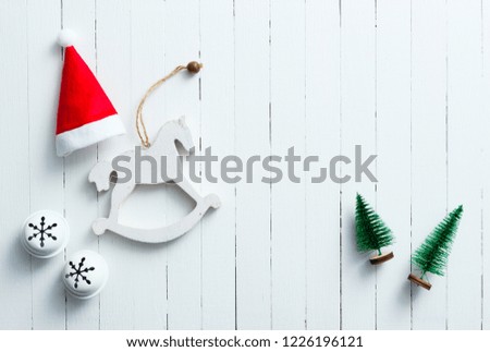 Santa hat, rocking horse and Christmas tree ornaments on white wooden