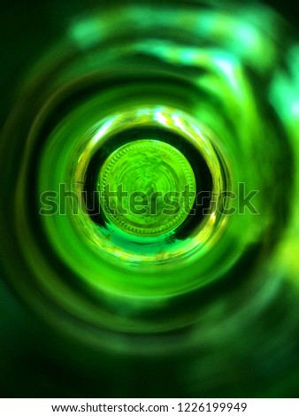Close up view to the Bottom of green bottle. Top view from the blurred neck.