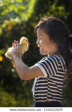 asia children girl holds a duck in hands. girl smile feel happy