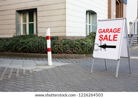 Garage Sale Text With Directional Sign On Board Near House