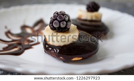 Delicious chocolate sponge cake with banana and blueberry layers, topped with chocolate icing