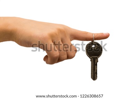 The keys to the doors of the new house hang on the index finger against a white background