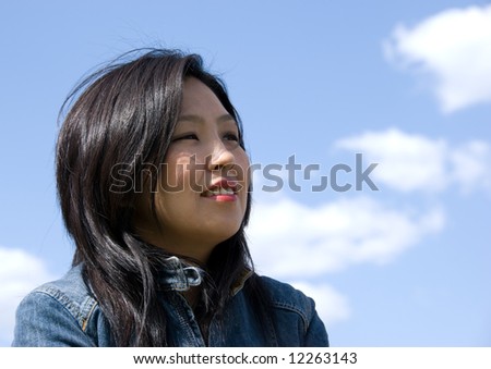 Attractive young woman portrait over sky background with room for text