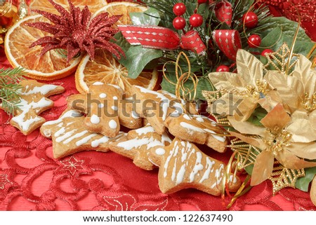 christmas background with needles. orange slices and gingerbreads on red