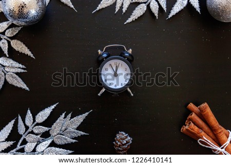 Christmas New Year Composition winter objects clock silver branch, baubles and balls on dark black background. Flat lay, top view, copy space. Christmas december time for celebration concept