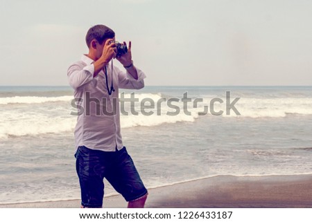 A man is taking pictures on the background of the sea