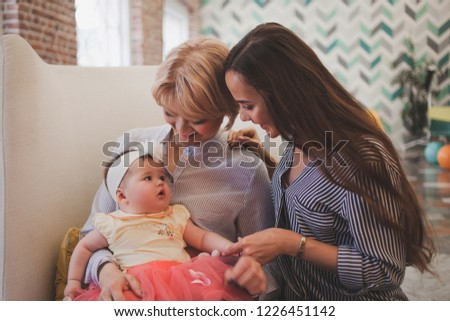 Family dinner. Family receives guests, a festive meeting. Mom and adult daughter holding baby granddaughter