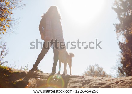 Young woman on a walk with her dog breed Akita inu. young woman, the dog's owner, portrait on the top, silhouette