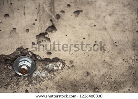 Bolt with nut and washer in a broken concrete wall