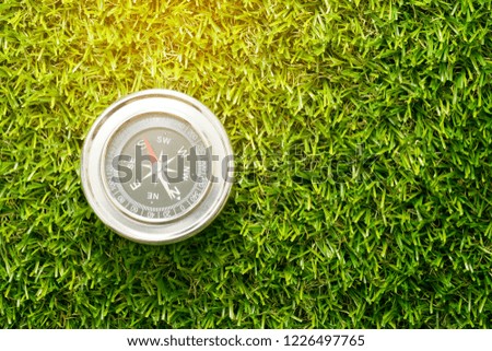 Compass on green grass with copy space,top view