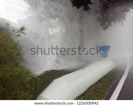 Splashing water fountain from a broken or leaking pipeline 