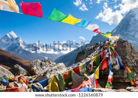 Colorful prayer flags on the Everest Base Camp trek in Himalayas, Nepal. View of Mount Ama Dablam and Mount Kangtega. Royalty-Free Stock Photo #1226560879