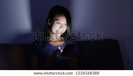 Woman use of cellphone at home in the evening