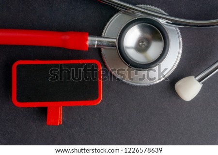A stethoscope and blackboard on dark background with selective focus and crop fragment. Medical, health and education concepts. Copy space