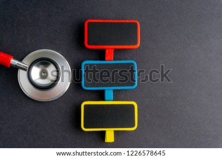 A stethoscope and blackboard on dark background with selective focus and crop fragment. Medical, health and education concepts. Copy space