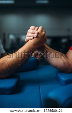 Joined male hands at the table, wrestling concept