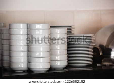 Stacks of Clean White Bowls in a Modern Restaurant Kitchen. 
