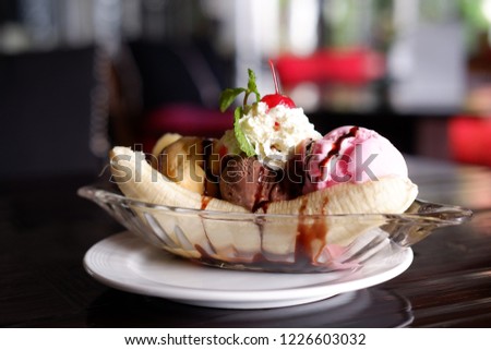 banana split ice cream on wood table Royalty-Free Stock Photo #1226603032
