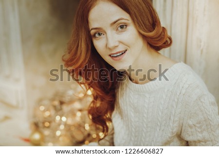 Good mood. Attractive girl keeping smile on her face and bowing head while looking forward