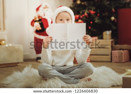 I did it. Positive delighted kid feeling happiness while having Christmas mood, sitting on fur
