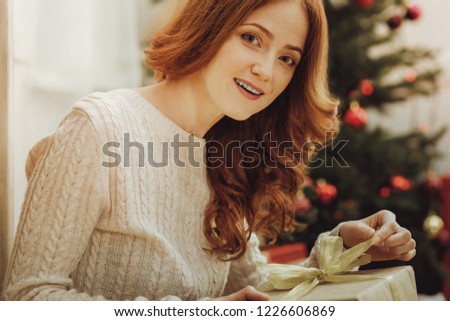 Cannot wait. Attractive red haired girl expressing positivity while having Christmas mood, being at home